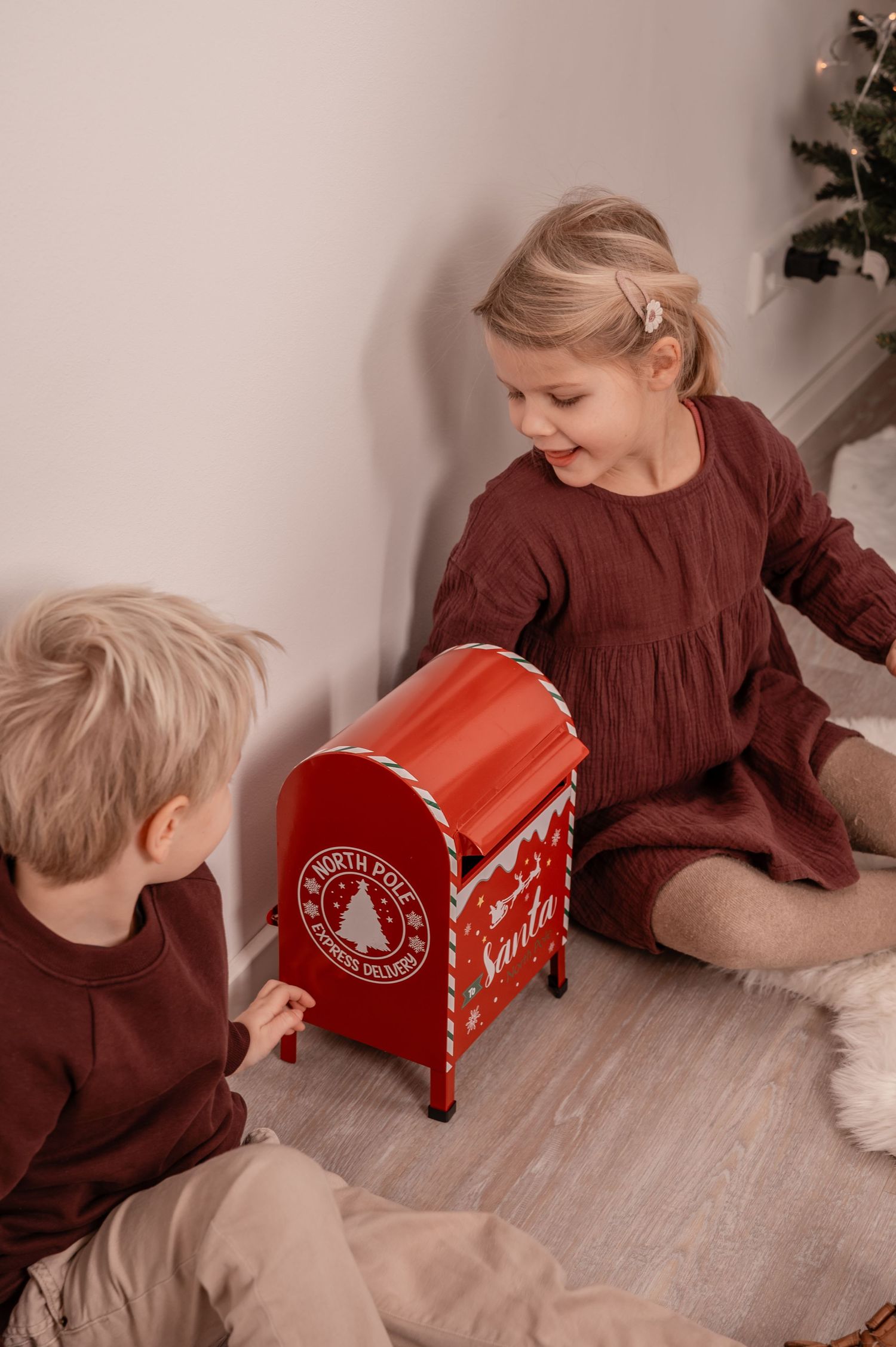 Kinder spielen mit Weihnachtsbriefkasten